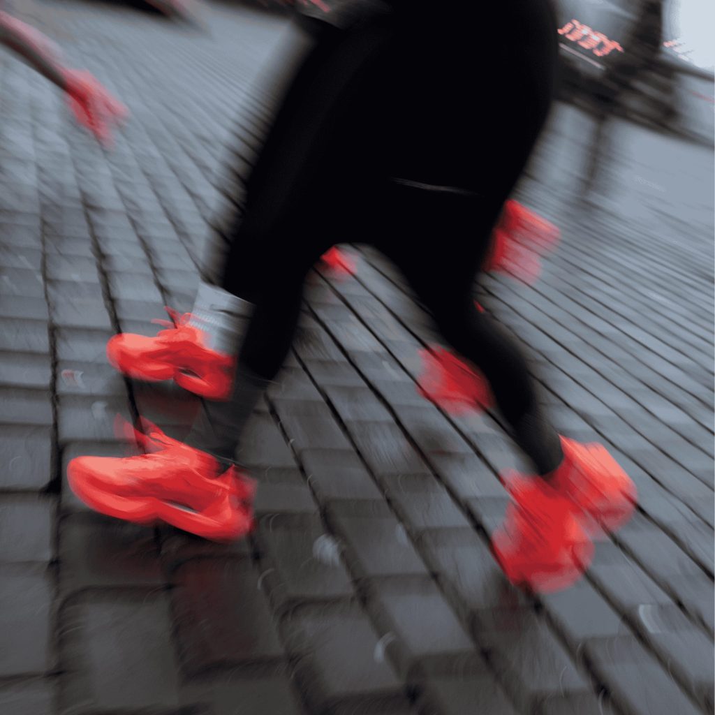 Motion-blurred runners in bright orange on cobblestones during the CEP testrun activation at ISPO 2025